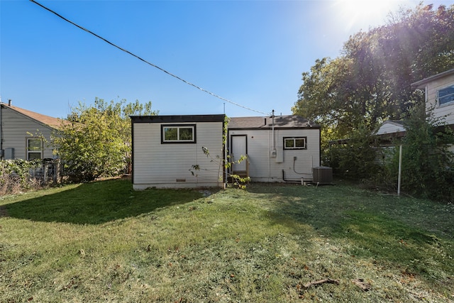 rear view of house with a yard and central air condition unit