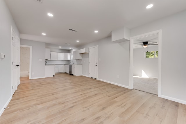 unfurnished living room featuring sink, light wood-type flooring, and ceiling fan