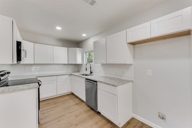 kitchen with sink, white cabinets, stainless steel appliances, and light hardwood / wood-style floors