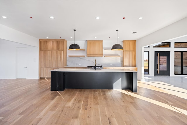 kitchen featuring a large island, light hardwood / wood-style flooring, and decorative light fixtures