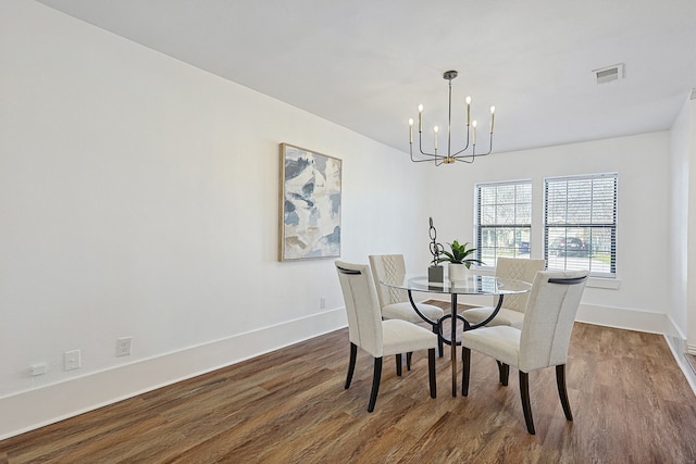 dining room featuring hardwood / wood-style flooring and an inviting chandelier