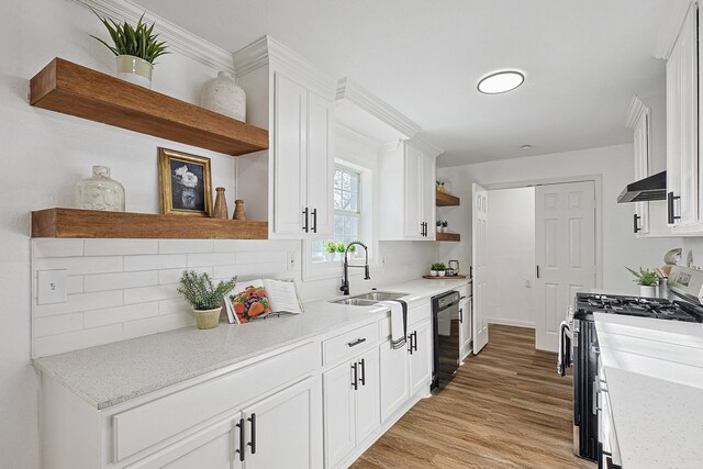 kitchen with white cabinets, stainless steel gas stove, backsplash, and black dishwasher