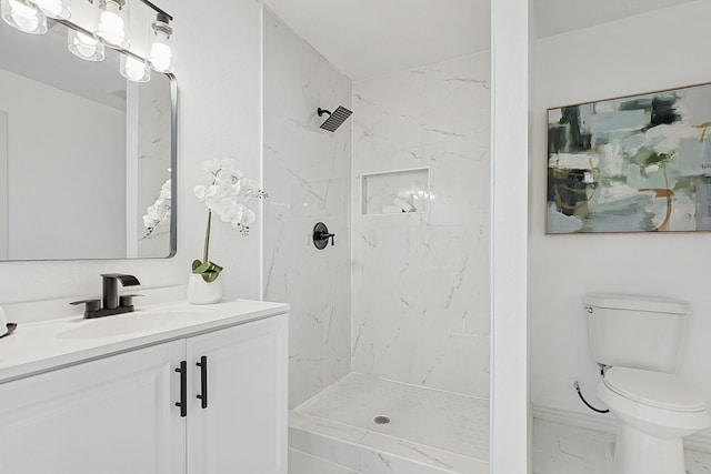 bathroom featuring vanity, toilet, and tiled shower