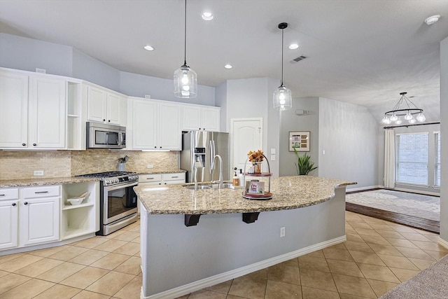 kitchen featuring stainless steel appliances, an island with sink, white cabinetry, and light tile patterned floors