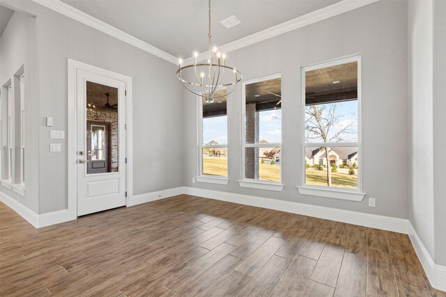 unfurnished dining area featuring hardwood / wood-style flooring, ceiling fan with notable chandelier, and ornamental molding