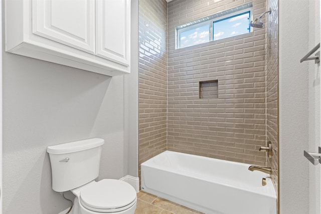 bathroom with tile patterned floors, toilet, and tiled shower / bath