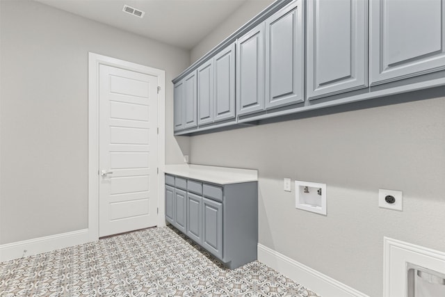 laundry room with hookup for an electric dryer, light tile patterned flooring, cabinets, and hookup for a washing machine