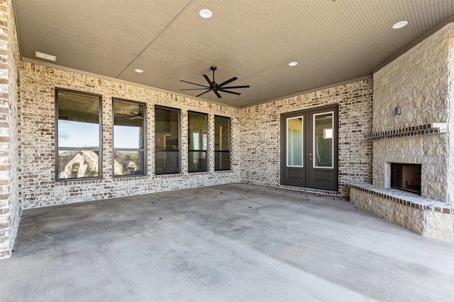 view of patio featuring ceiling fan, french doors, and an outdoor stone fireplace