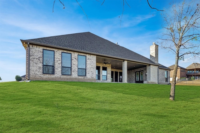 back of house featuring a lawn and ceiling fan