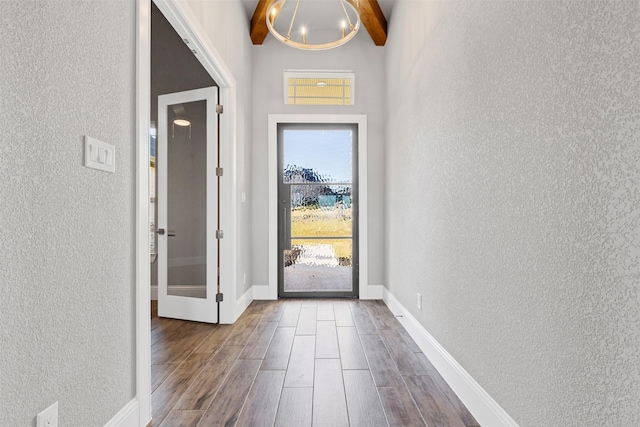 doorway featuring beamed ceiling and hardwood / wood-style floors