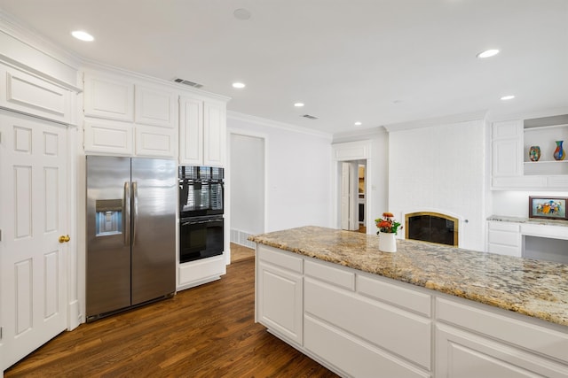 kitchen with light stone countertops, stainless steel fridge with ice dispenser, dark hardwood / wood-style floors, and white cabinets