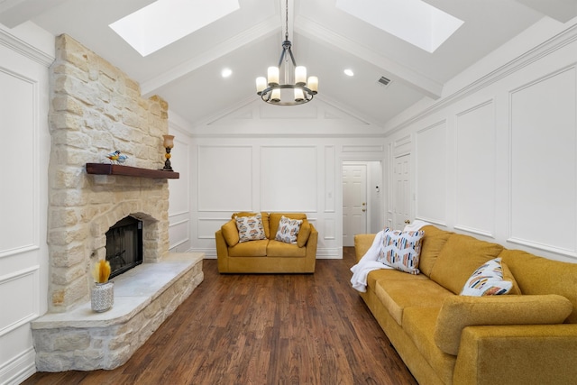 living room featuring a notable chandelier, lofted ceiling with beams, dark hardwood / wood-style floors, and a stone fireplace