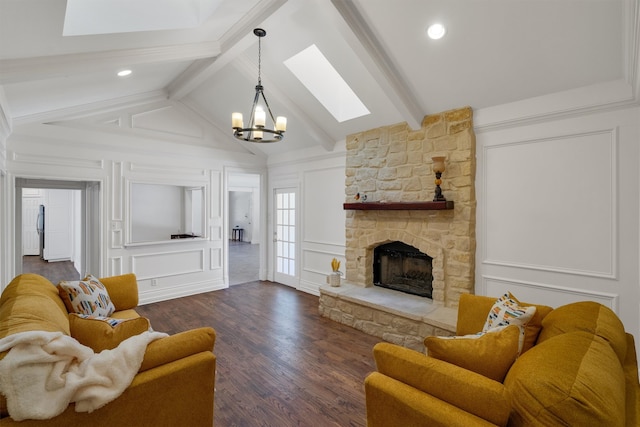 living room with a stone fireplace, a notable chandelier, lofted ceiling with skylight, and dark wood-type flooring