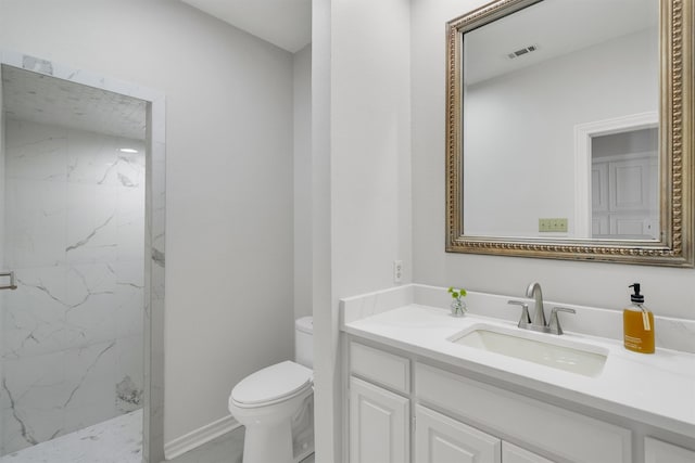 bathroom featuring vanity, toilet, and tiled shower