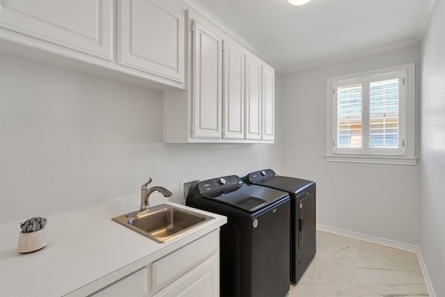 clothes washing area with ornamental molding, sink, separate washer and dryer, and cabinets