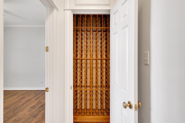 wine area with crown molding and hardwood / wood-style flooring