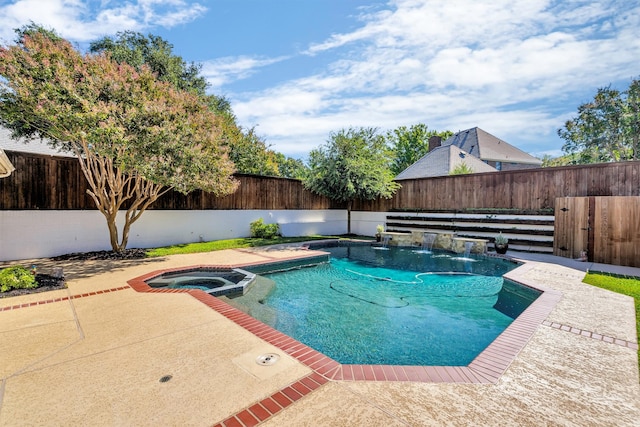 view of pool featuring a patio area, pool water feature, and an in ground hot tub