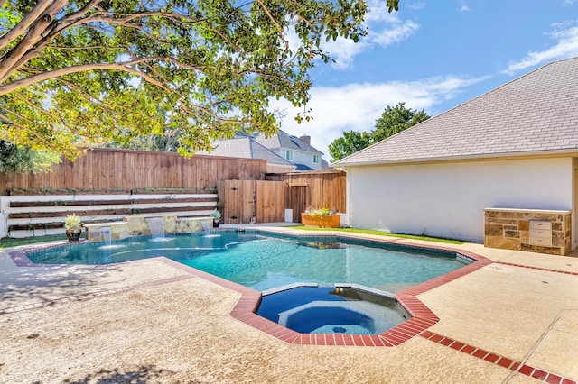 view of pool with an in ground hot tub, a patio, and pool water feature