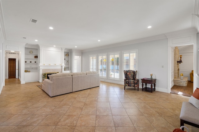 tiled living room featuring crown molding, a large fireplace, and built in shelves