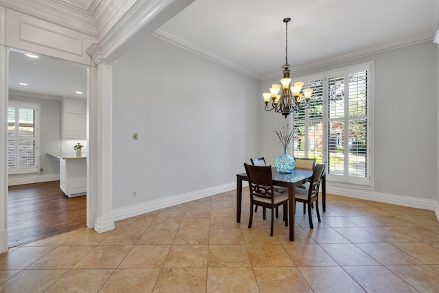 dining space with a notable chandelier, ornamental molding, and light wood-type flooring