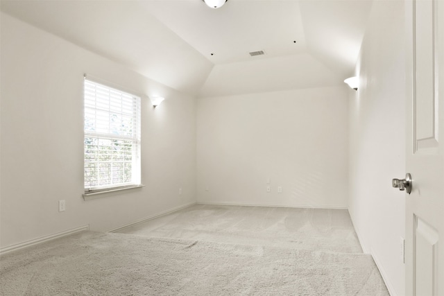 carpeted spare room featuring lofted ceiling