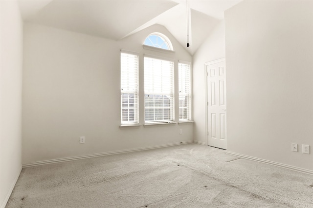 carpeted empty room featuring lofted ceiling