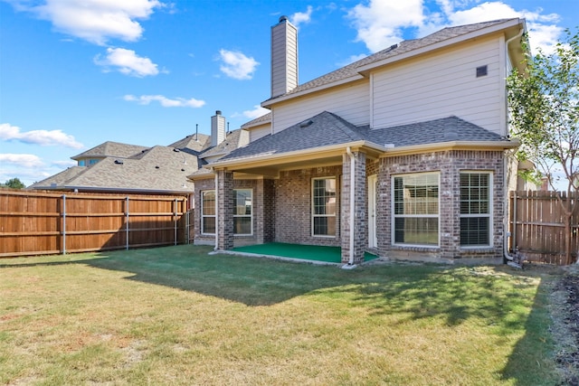 back of property with a patio and a lawn