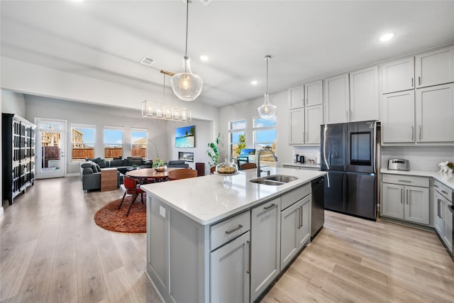 kitchen with light hardwood / wood-style flooring, gray cabinetry, stainless steel appliances, sink, and pendant lighting