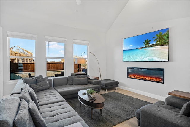 living room with vaulted ceiling and light wood-type flooring