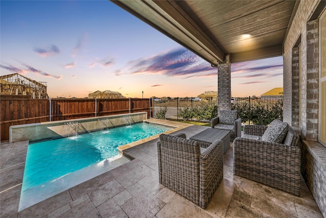 pool at dusk featuring pool water feature and a patio