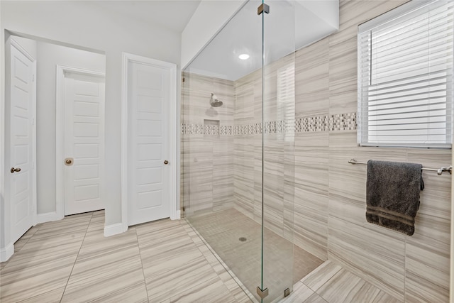 bathroom featuring a tile shower and tile patterned flooring