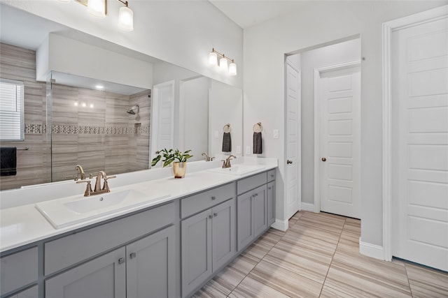 bathroom with a tile shower, vanity, and tile patterned floors