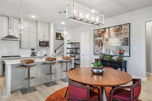 dining area with sink and light wood-type flooring