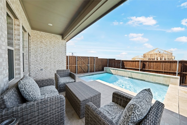 view of pool with an outdoor living space, pool water feature, and a patio area