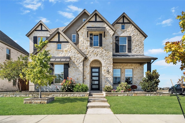 tudor-style house featuring a front yard