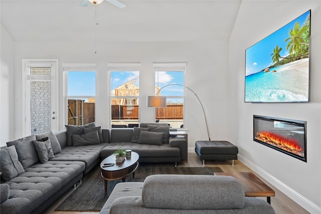 living room featuring ceiling fan, hardwood / wood-style flooring, and lofted ceiling