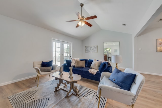 living room featuring french doors, light hardwood / wood-style floors, vaulted ceiling, and ceiling fan