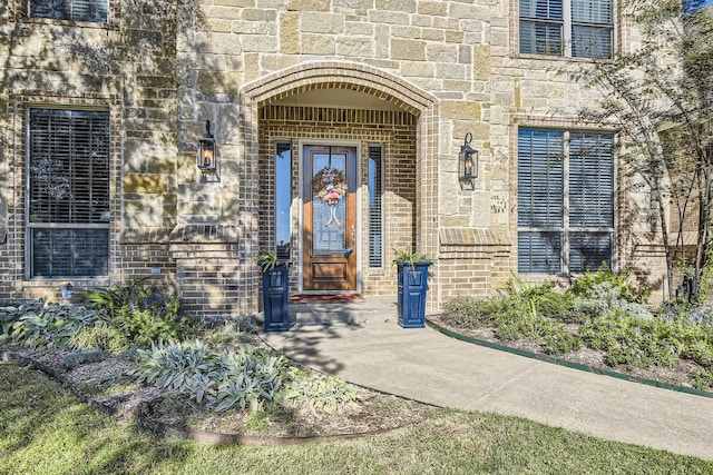 doorway to property with stone siding and brick siding