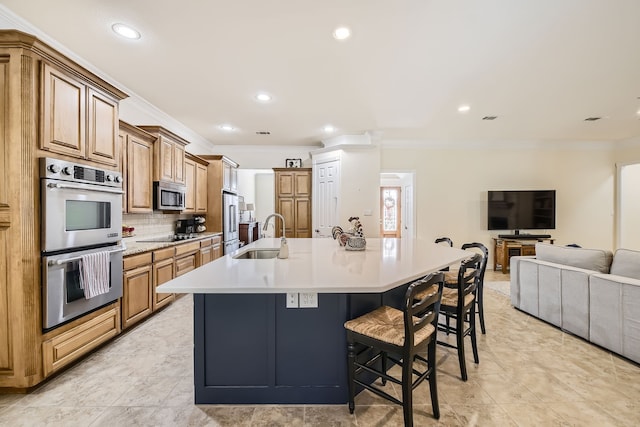 kitchen featuring a spacious island, a kitchen breakfast bar, sink, crown molding, and stainless steel appliances