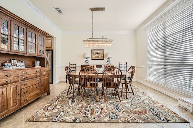 dining room featuring a notable chandelier, ornamental molding, and light tile patterned floors