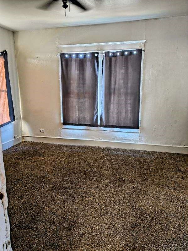 empty room featuring carpet flooring and ceiling fan