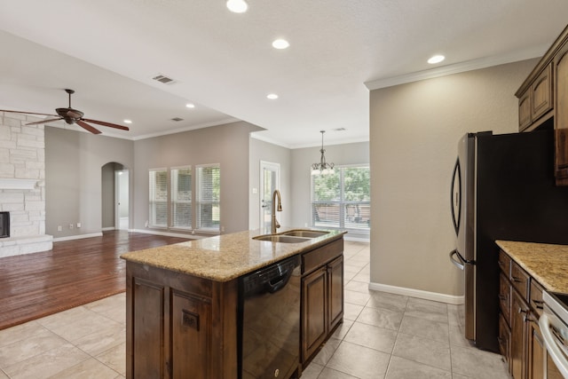 kitchen featuring a kitchen island with sink, light hardwood / wood-style flooring, stainless steel appliances, sink, and light stone counters