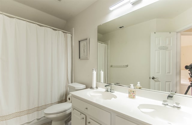 bathroom featuring vanity, curtained shower, and toilet