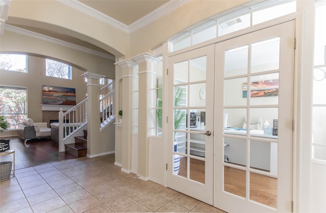 doorway to outside with french doors, ornate columns, crown molding, and light wood-type flooring