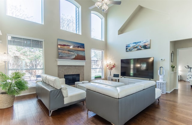 living room featuring a wealth of natural light, dark wood-type flooring, and a towering ceiling