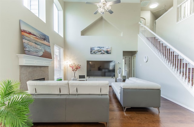 living room with a fireplace, dark hardwood / wood-style floors, a high ceiling, and a wealth of natural light