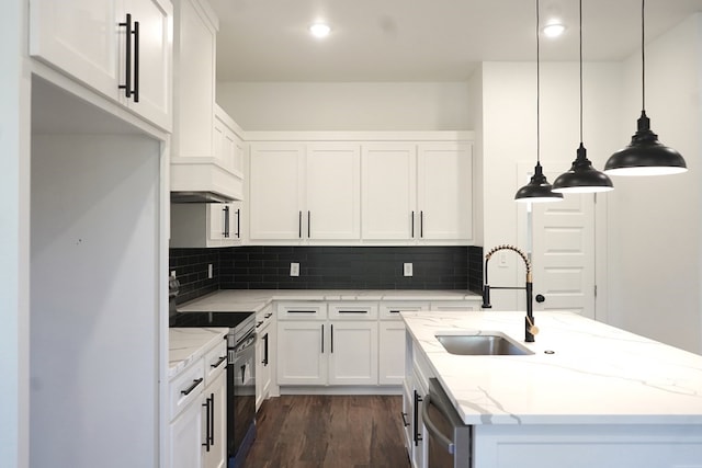 kitchen with light stone counters, white cabinetry, stainless steel appliances, sink, and decorative light fixtures