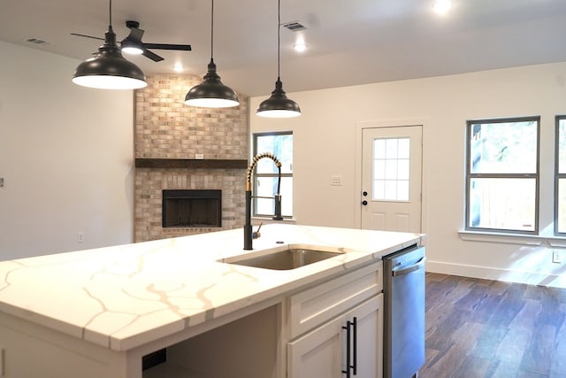 kitchen with dishwasher, dark hardwood / wood-style floors, sink, white cabinetry, and light stone counters