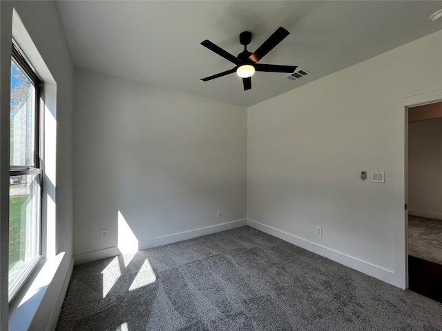 carpeted spare room featuring ceiling fan