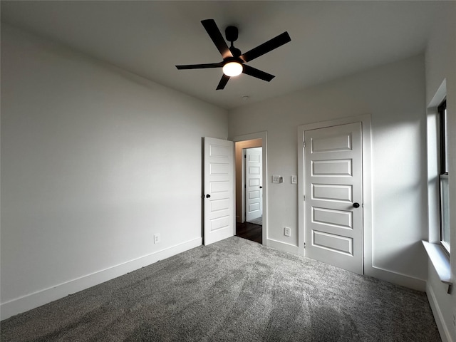 unfurnished bedroom featuring dark carpet and ceiling fan